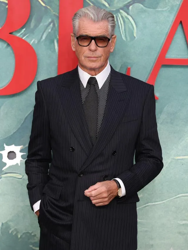 Pierce Brosnan in a pinstripe suit and sunglasses at a premiere