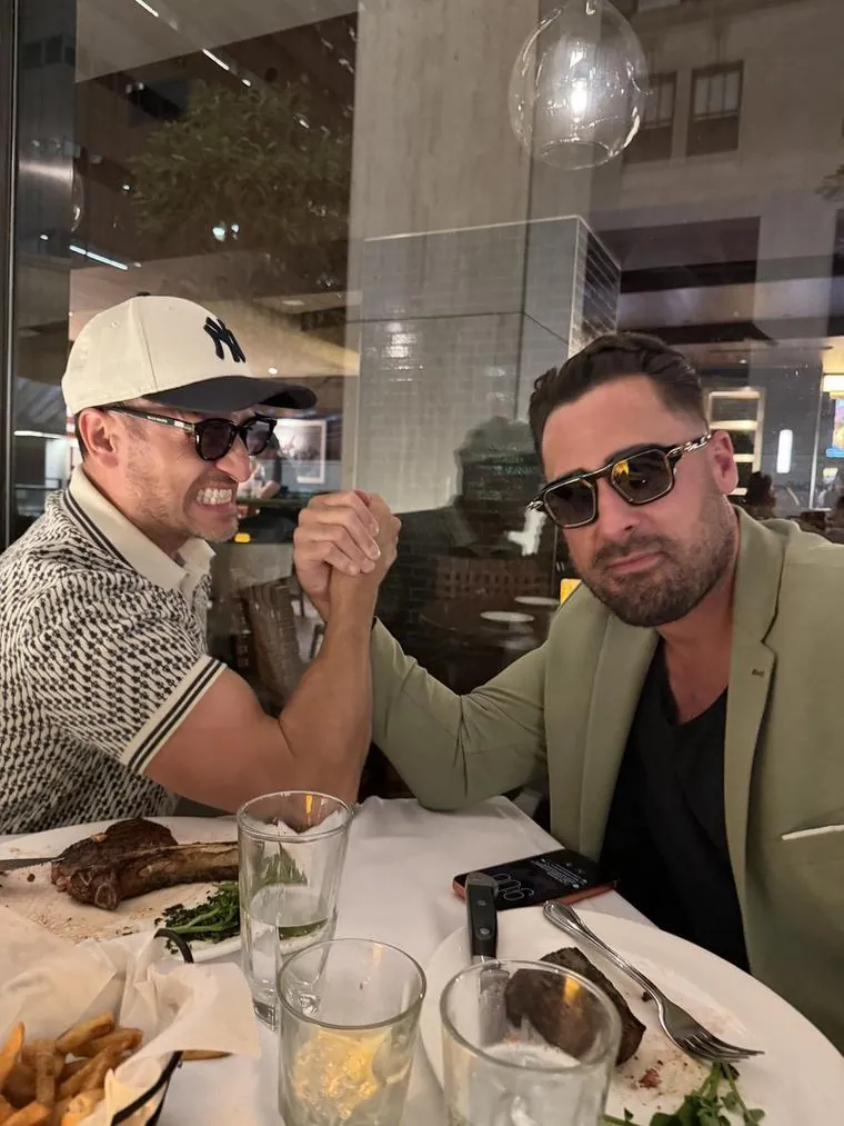 A friend and me arm wrestling over steaks at dinner