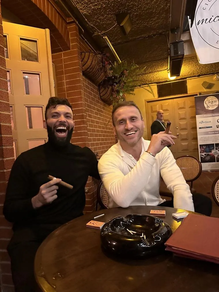 A friend and me laughing with cigars at a cigar bar
