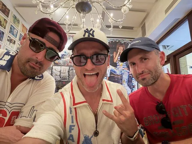 Three of us in sunglasses, tongues out, in a shop
